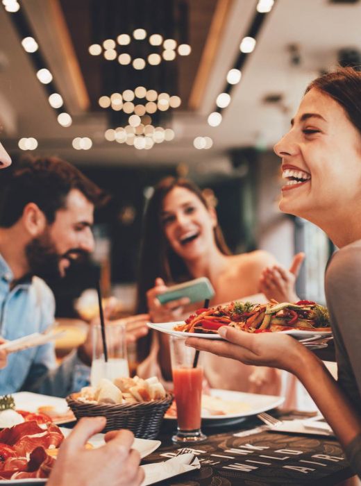 Friends enjoying a meal at a restaurant near Rowe Residences in Victoria, MN.